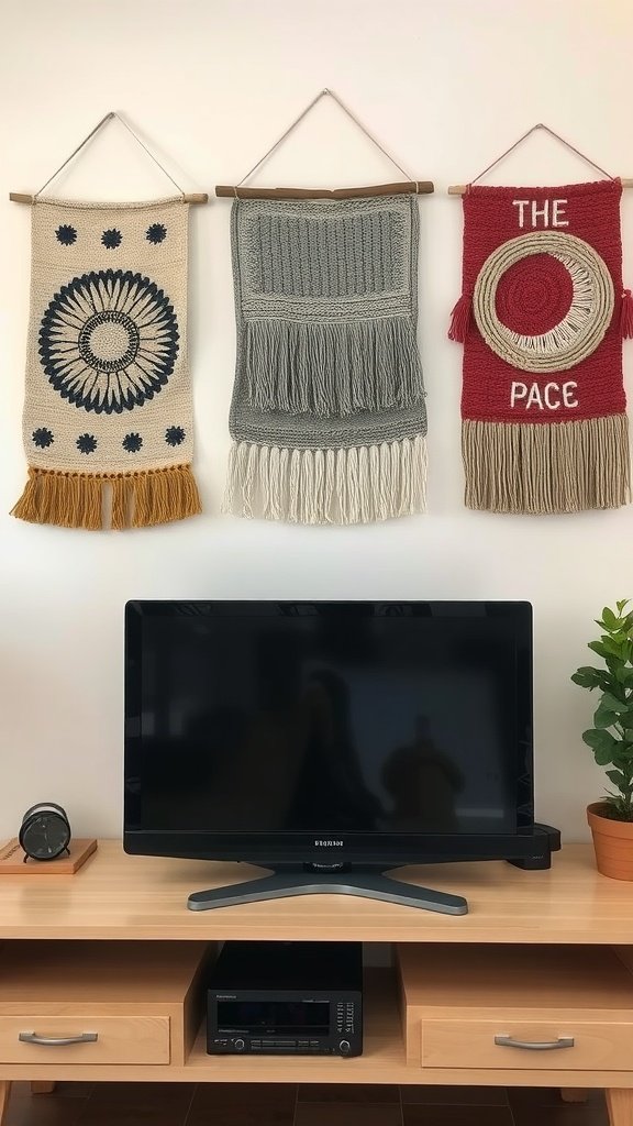 Three textile wall hangings above a TV, featuring different designs and colors.